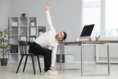 Ofiste sandalyeye uzanan yakışıklı adam.