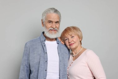 Gri arka planda sevimli yaşlı çift portresi