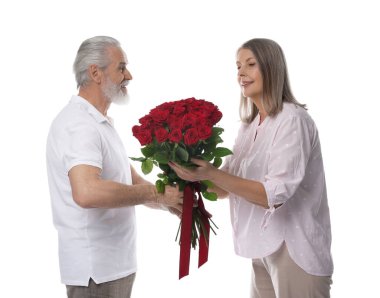 Adam beyaz arka planda mutlu karısına kırmızı gül buketi sunuyor.
