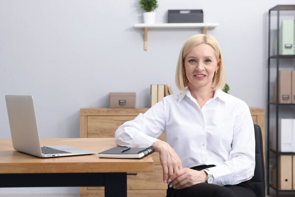 Профессиональный психолог за столом с ноутбуком в офисе