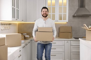 Taşınma günü. Yeni evinde karton kutuları olan bir adam.