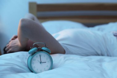 Evde yatakta uykusuzluk çeken sinirli genç kadın, alarma odaklan.