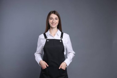 Gri arka planda gülümseyen baristanın portresi