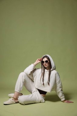 Yeşil arka planda şık giyinmiş güzel bir kadının moda portresi.