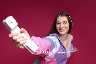 Kırmızı arka planda şık giyinmiş güzel bir kadının moda portresi.