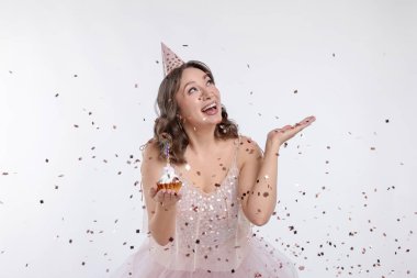 Doğum günü kutlaması. Beyaz arka planda kek ve konfeti olan kadın.