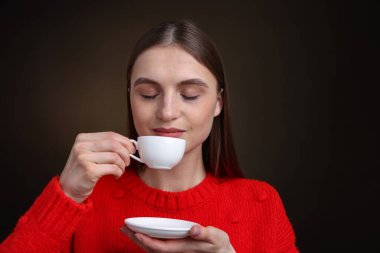 Kahverengi renkte fincandan kahve içen kadın