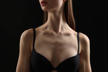 Siyah arka planda sutyen giyen kadın, yakın plan.