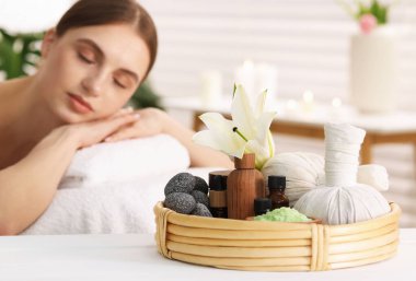 Güzel bir kadın masaj salonundaki masaj koltuğunda dinleniyor, seçici bir odak noktası.