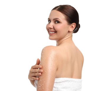 Gülümseyen kadın beyaz arka planda vücudunu koluna ovalıyor.