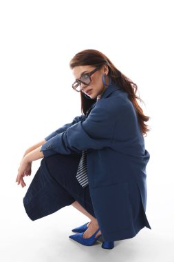 Beyaz arka planda şık giyinmiş genç bir kadın.