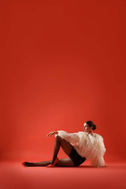 Kırmızı arka planda şık giyinmiş genç kadın, mesaj için yer var.