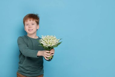 Açık mavi arka planda vadideki güzel çiçekleri olan bir buket çocuk. Metin için boşluk