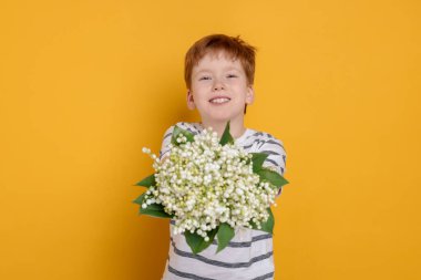 Sarı arka planda bir buket güzel çiçekli çocuk.