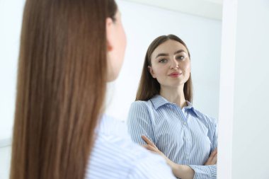 Güzel bir kadın aynada kendine bakıyor.