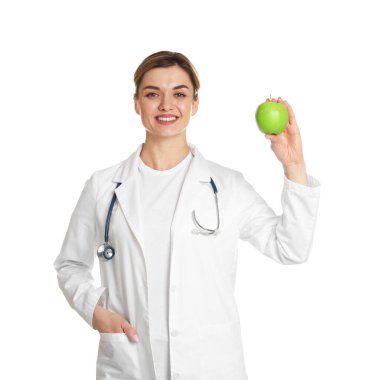 Beyaz arka planda yeşil elmalı ve steteskoplu beslenme uzmanı.