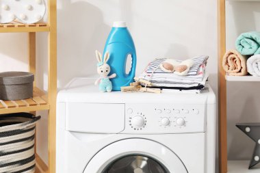 Kumaş yumuşatıcısı, bebek kıyafetleri, mandallar ve çamaşır makinesinde oyuncaklar.