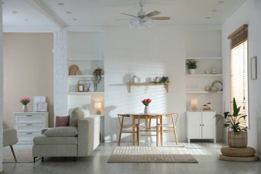 Odada rahat bir kanepe ve sandalyeli şık bir yemek masası. İç tasarım