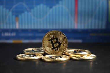 Kripto para birimi. Veri tablolarına karşı siyah tablodaki bitcoinler, yakın plan