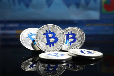 Kripto para birimi. Ayna yüzeyinde gümüş bitcoinler, yakın plan