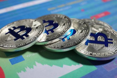 Kripto para birimi. Veri tablolarındaki gümüş bitcoinler, yakın plan
