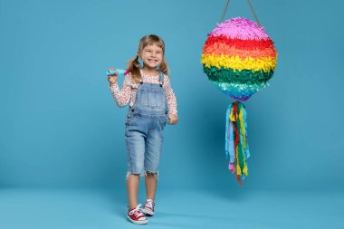 Parlak pinyatalı ve açık mavi arka planda mutlu bir kız.