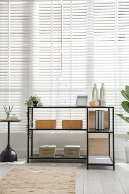 Pencerenin yanında farklı dekorları olan konsol masası. İç tasarım