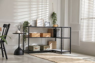 Beyaz duvarın yanında farklı dekorları ve sandalyeleri olan konsol masası. İç tasarım