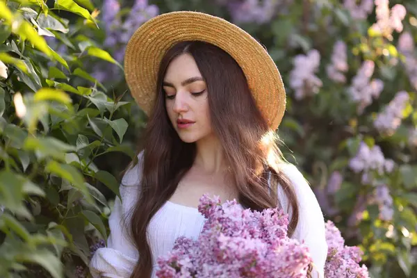 Leylak çiçeklerinin arasında güzel bir kadın ve açık havada bırakır