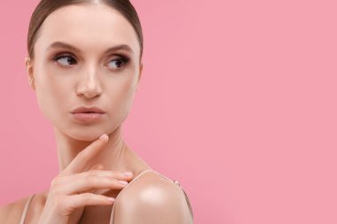 Pembe arka planda güzel bir genç kadının portresi, metin için boşluk