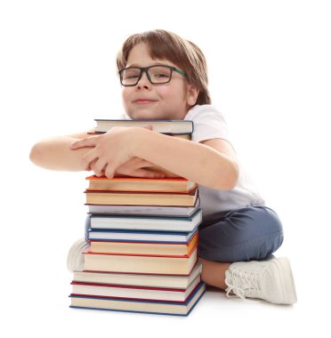 Beyaz arka plan hakkında çok farklı kitapları olan bir çocuk.