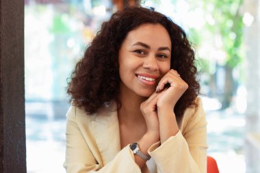 Kafedeki gülümseyen Latin Amerikalı kadının portresi.