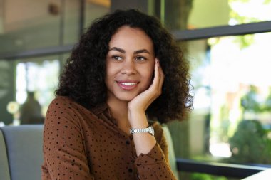 Kafedeki gülümseyen Latin Amerikalı kadının portresi.