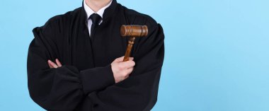 Açık mavi arka planda çekiçli yargıç, yakın plan. Metin için boşluk