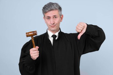 Gri arkaplanda baş parmak gösteren tokmakla hakim