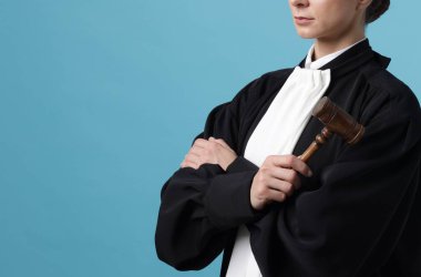 Açık mavi arka planda çekiçli yargıç, yakın plan. Metin için boşluk