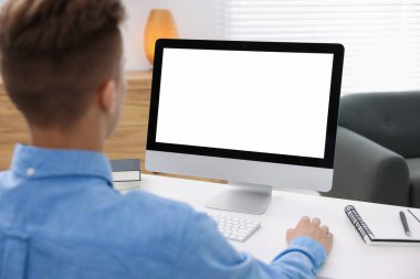 Ofisteki beyaz masada bilgisayarda çalışan bir adam, yakın plan. Tasarım için model