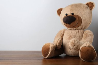 Küçük arka planda tahta masada sevimli bir oyuncak ayı. Metin için boşluk