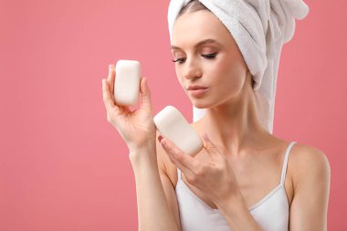 Pembe arka planda sabun çubukları olan güzel bir kadın. Metin için boşluk