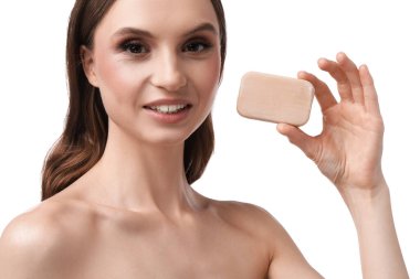 Beyaz arka planda sabun çubuğuyla gülümseyen kadın, yakın plan.