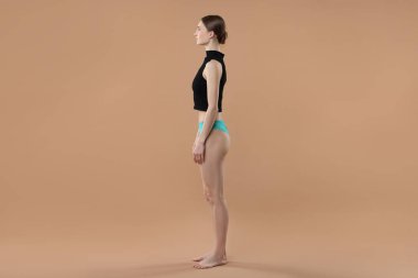 Bej arka planda güzel iç çamaşırı giyen bir kadın.