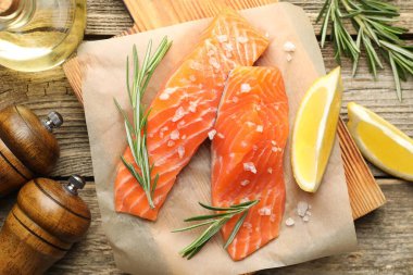 Deniz ürünleri. Somon fileto, baharat, yağ ve limon dilimleri ahşap masa üzerinde, düz yatıyordu.