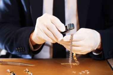 Sofrada lüks mücevherleri değerlendiren Loupe 'lu eksper, yakın plan.