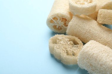 Açık mavi arka planda doğal lif süngeri, yakın plan. Metin için boşluk