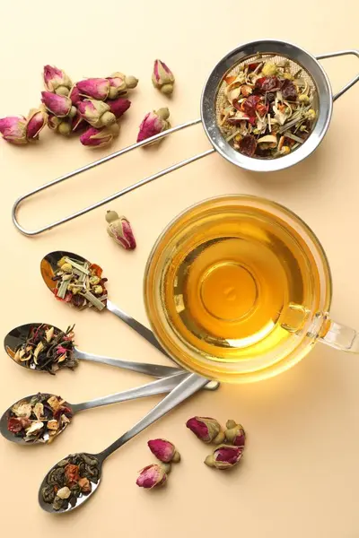 Cam fincanda nefis bitki çayı ve bej arka planda kuru yapraklar.