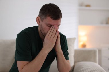 Evdeki kanepede depresif bir adam. Zihinsel sağlık sorunu