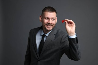 Hedef alınıyor. Gri arkaplanı hedefleyen dartlı adam.