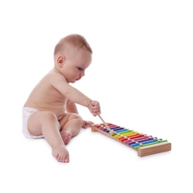 Beyaz arka planda ksilofonla oynayan şirin bir bebek.