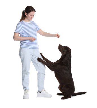 Mutlu kadın köpeğini beyaz arka planda eğitiyor.