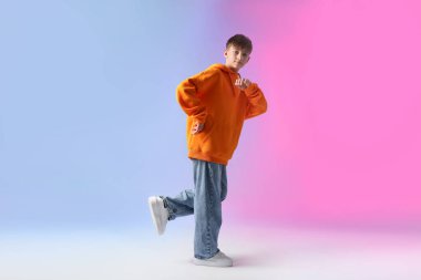 Renkli arka planda dans eden şık elbiseli çocuk.